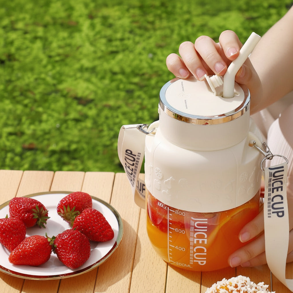 Hand holding a juice cup with strawberries on a wooden table.