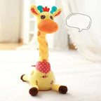 A yellow giraffe-shaped plush toy or baby product standing on a white surface in a softly lit indoor setting. It has an orange face, multicolored ears, a red polka-dot neck band, and a speech bubble with Chinese text.