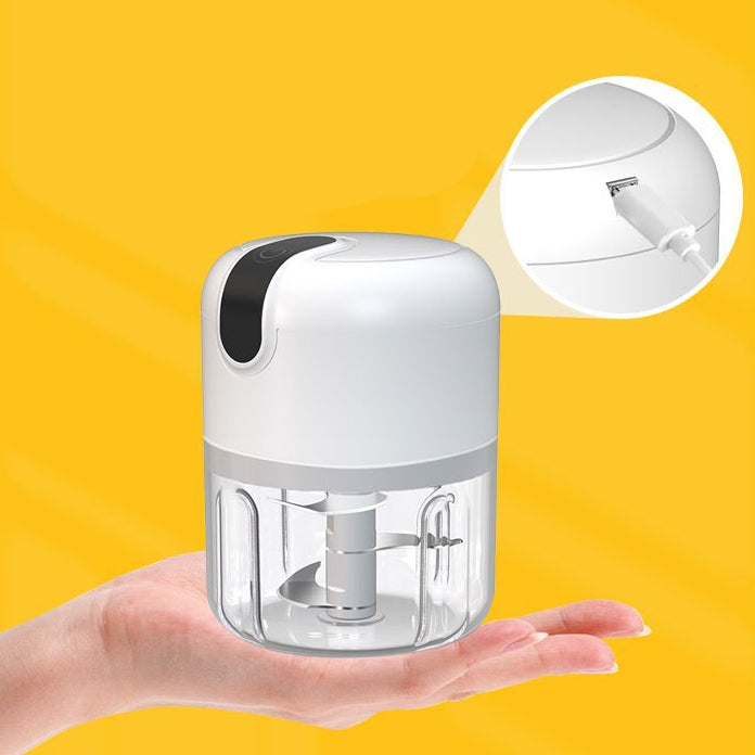 Small electric grinder held in a hand with yellow background.